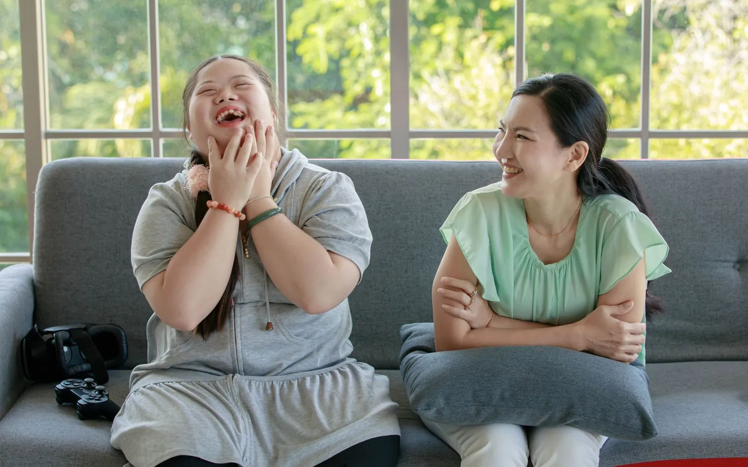 A care professional sharing a joyful moment with a young woman at home